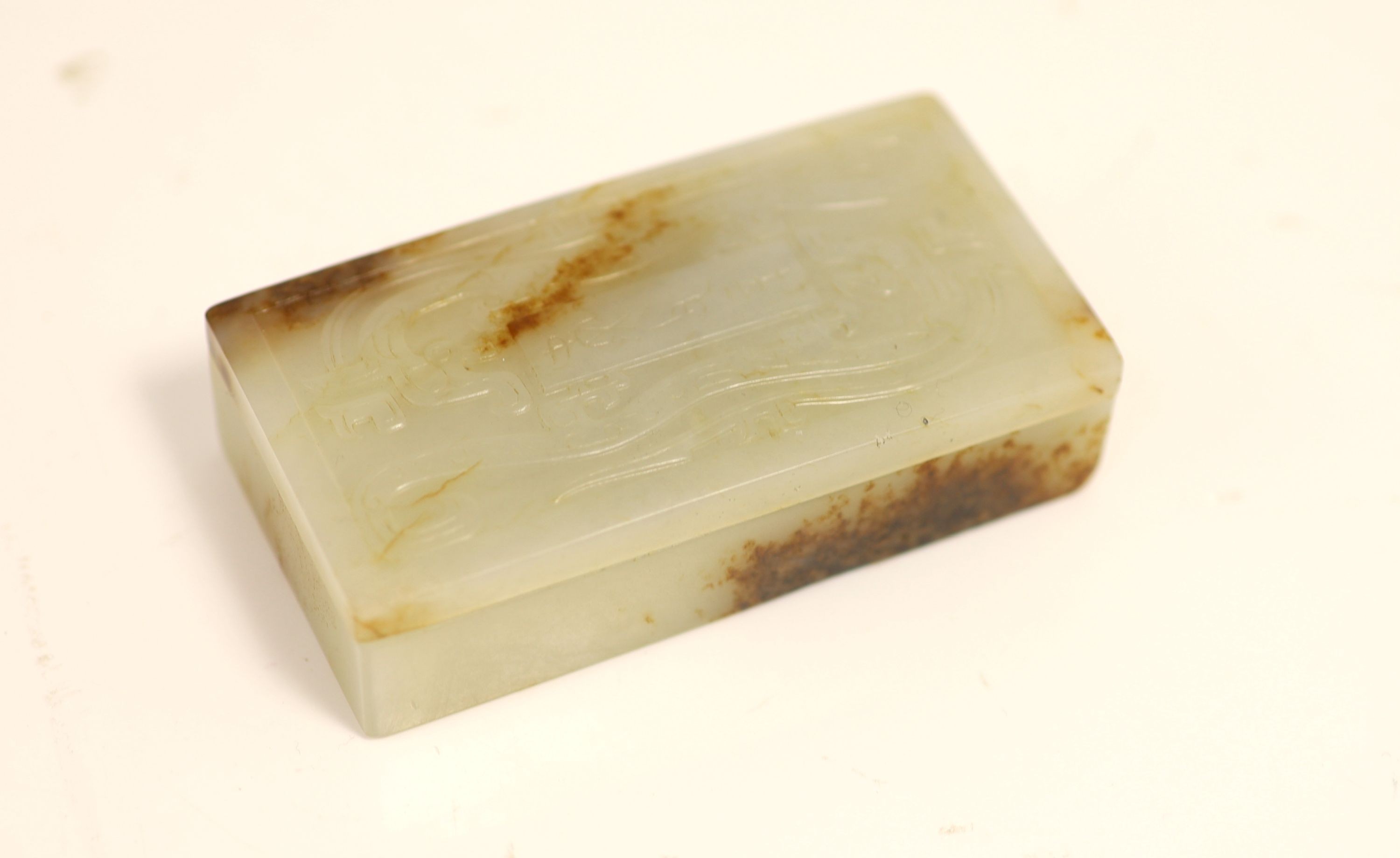 A Chinese archaistic white and brown jade box and cover, 8.3 x 4.3 cm
